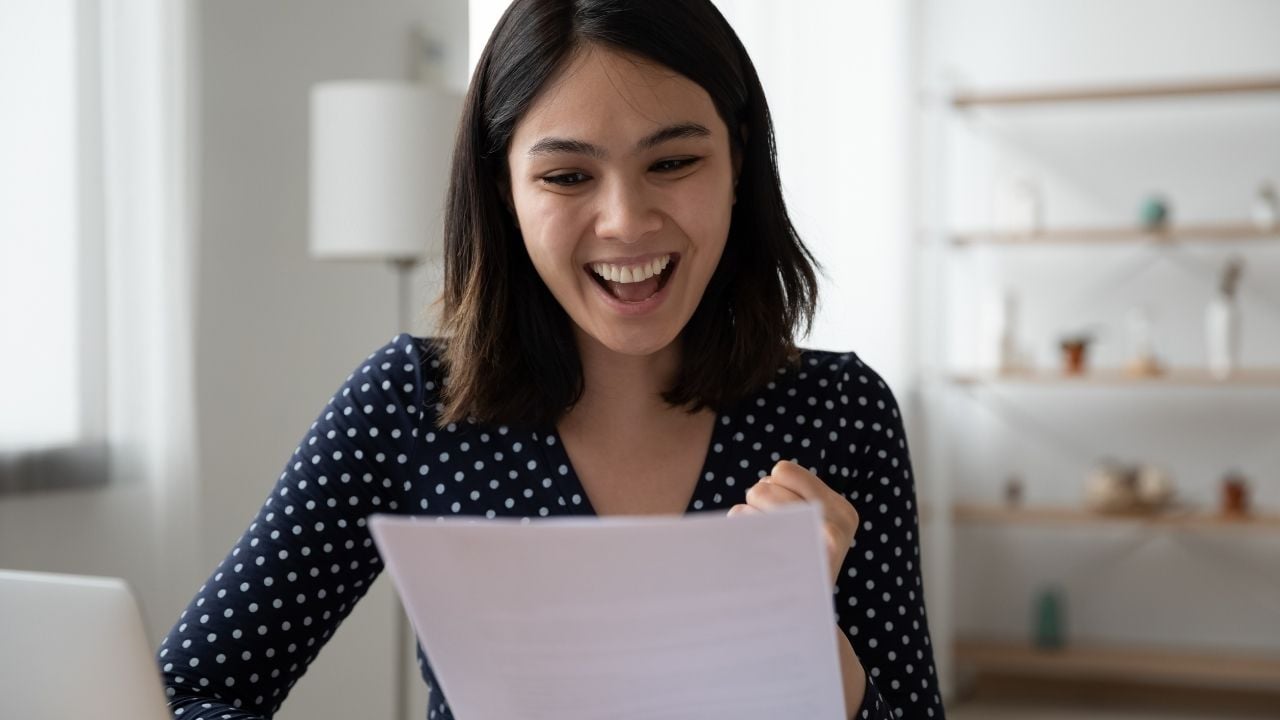 woman reacting to letter happy